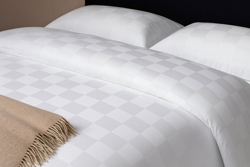 A checker pattern sheet set and duvet cover set in white color on a bed from Hometrend, a Canadian Bedding store 