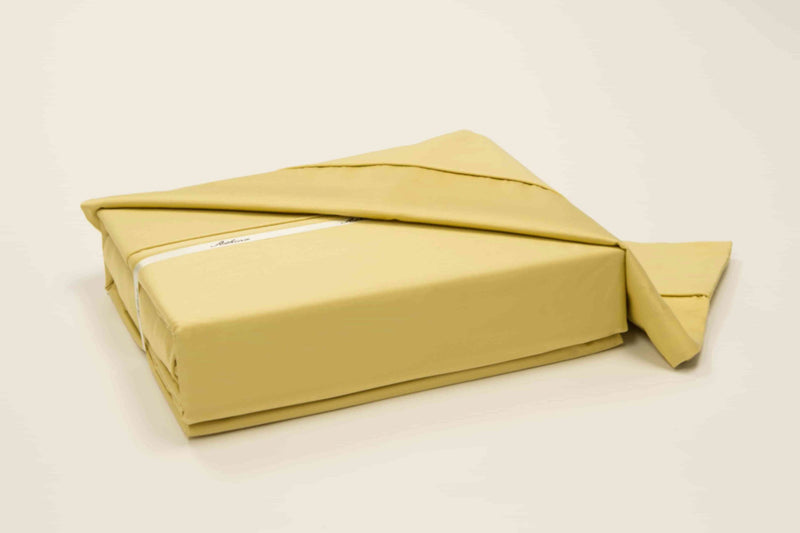 A 100% Long staple egyptian cotton sheet set including pillow cases in a yellow or gold color in an alternate angle