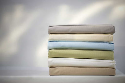 An pile of Athena 300 Thread Count Bamboo Cotton Sheet Sets in Green, White, Cream / Ivory, Blue, and Taupe Colours